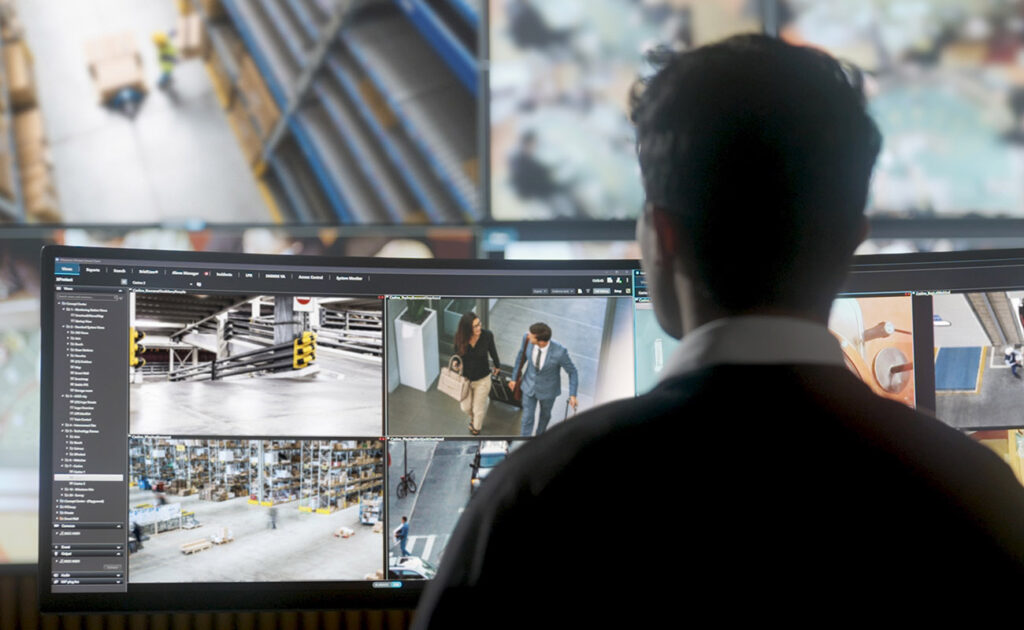 Pracownik obserwujący monitory w centrum monitoringu